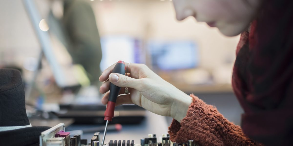 A person adjusting audio equipment with focused attention.